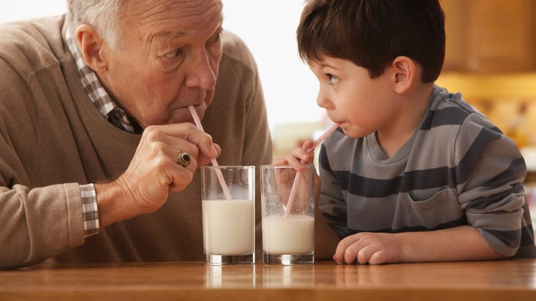 Großvater und Enkelkind trinken Milch zusammen: