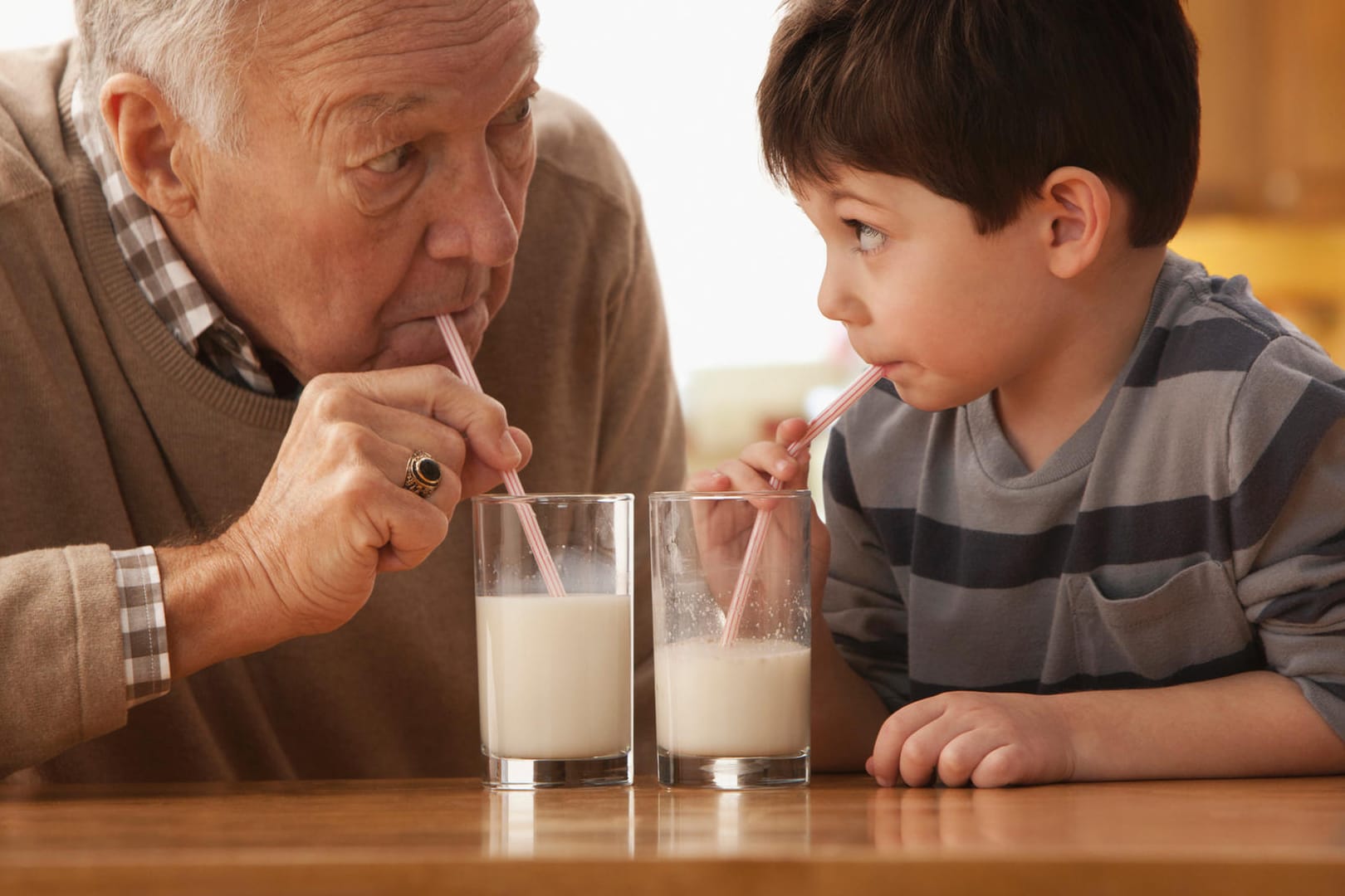 Großvater und Enkelkind trinken Milch zusammen: