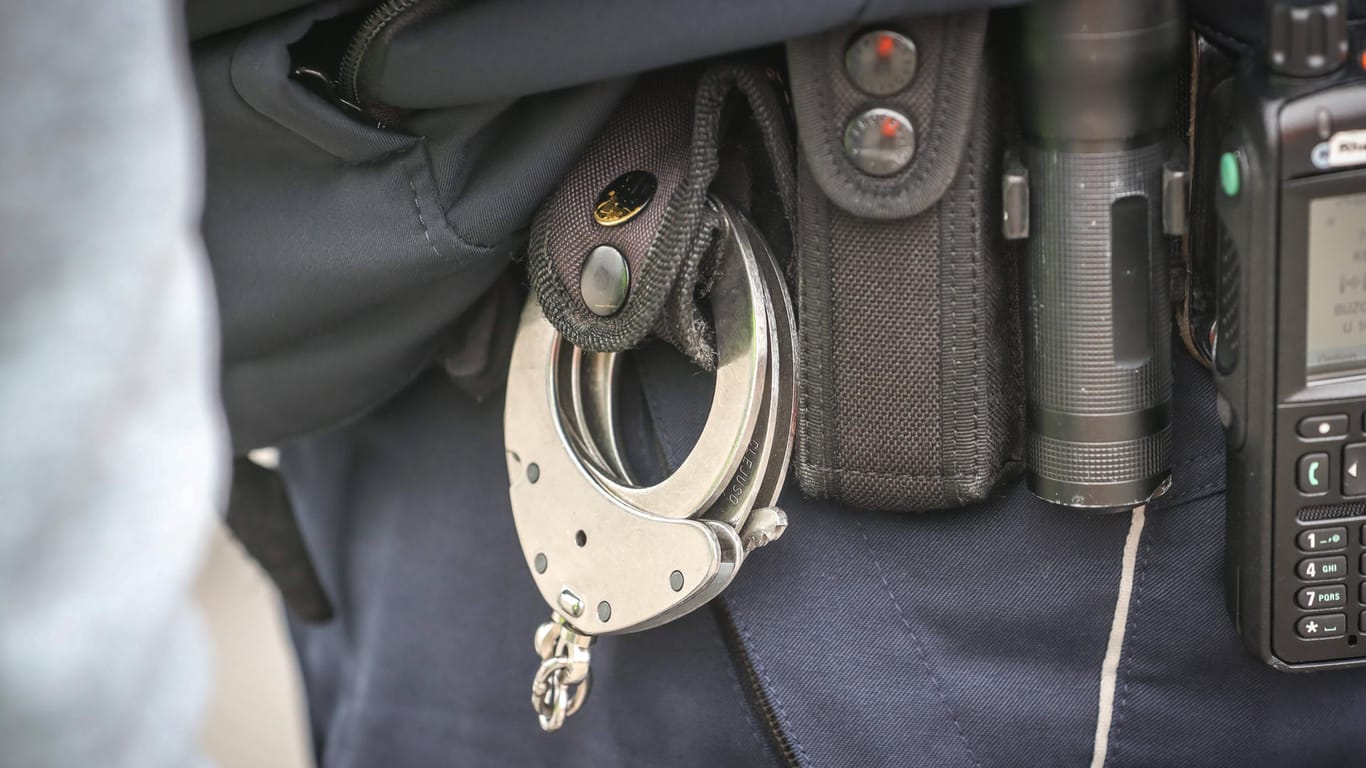 Handschellen hängen am Gürtel eines Polizeibeamten (Symbolbild): In Wuppertal ist ein mutmaßlicher Drogendealer festgenommen worden.