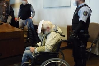 Angekettet an den Rollstuhl: Der 63-Jährige mutmaßliche Vergewaltiger einer 81-Jährigen konnte den Weg zur Anklagebank nicht auf eigenen Füßen zurücklegen.