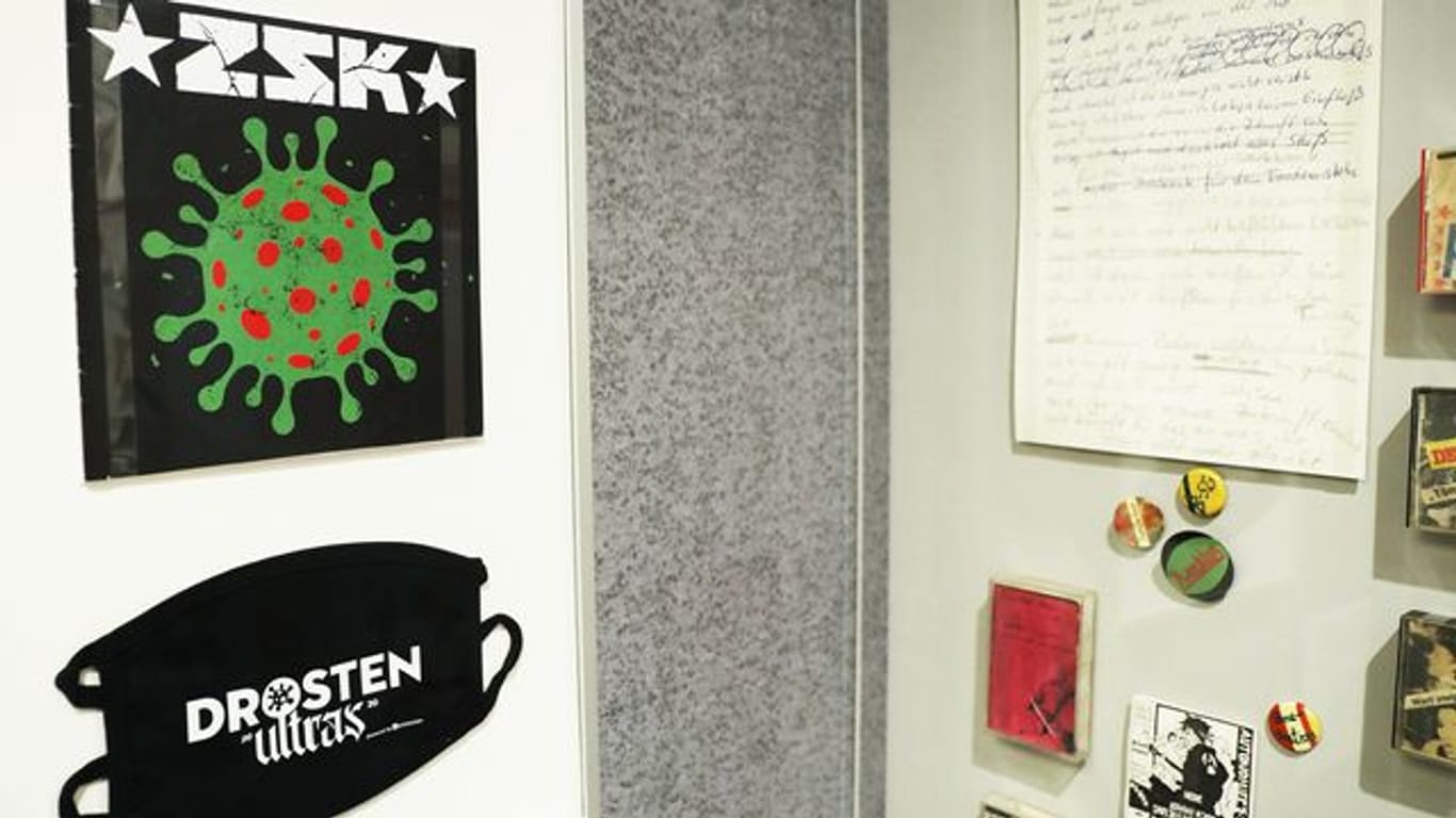 Die Single "Ich habe Besseres zu tun" über den Virologen Drosten und eine Maske mit der Aufschrift "Drosten Ultras" der Punkband ZSK in Bonn.