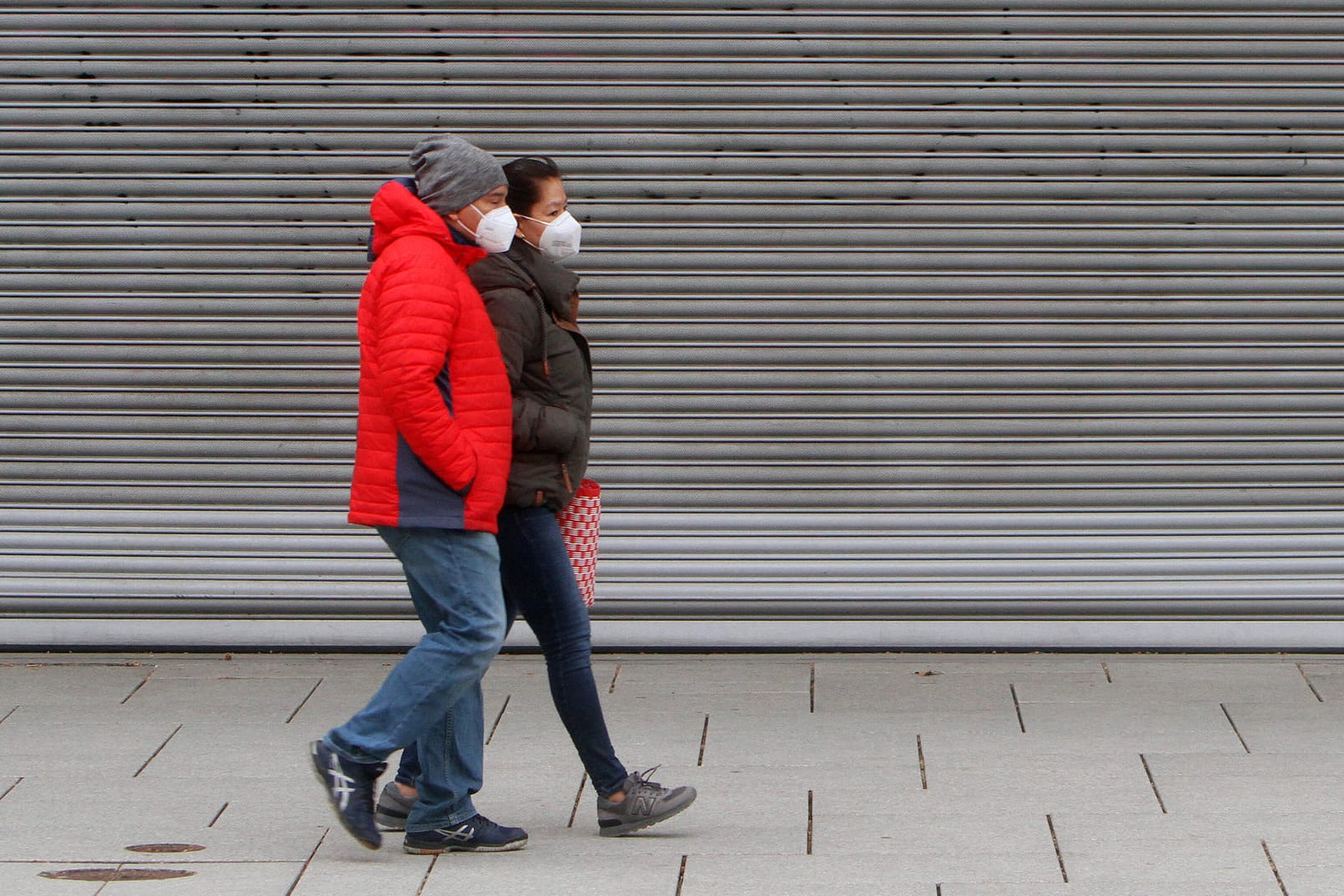 Personen mit Maske passieren geschlossenes Geschäft: Einige t-online-Leser sehen die aktuellen Corona-Maßnahmen als ungerecht an.