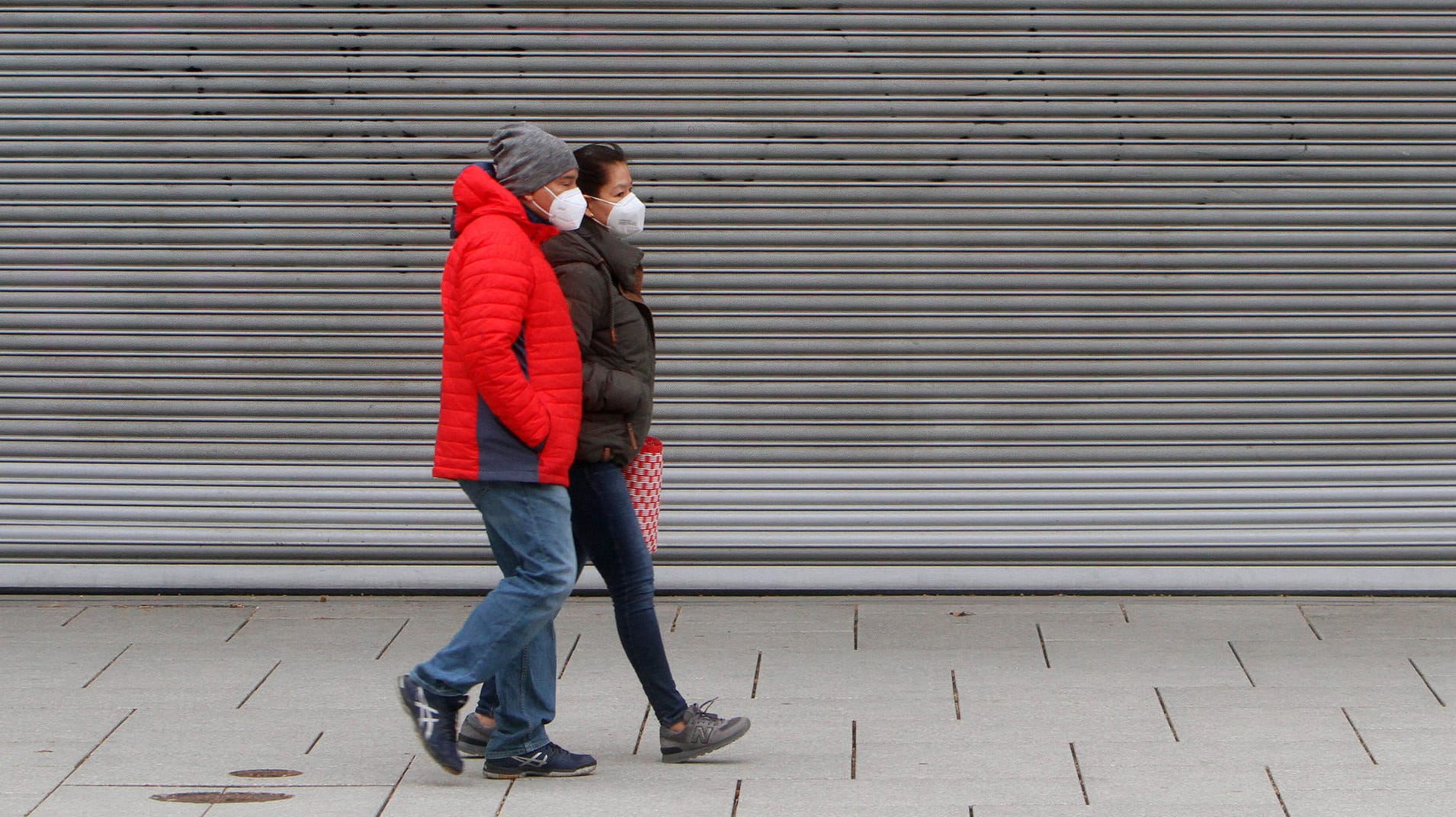 Personen mit Maske passieren geschlossenes Geschäft: Einige t-online-Leser sehen die aktuellen Corona-Maßnahmen als ungerecht an.