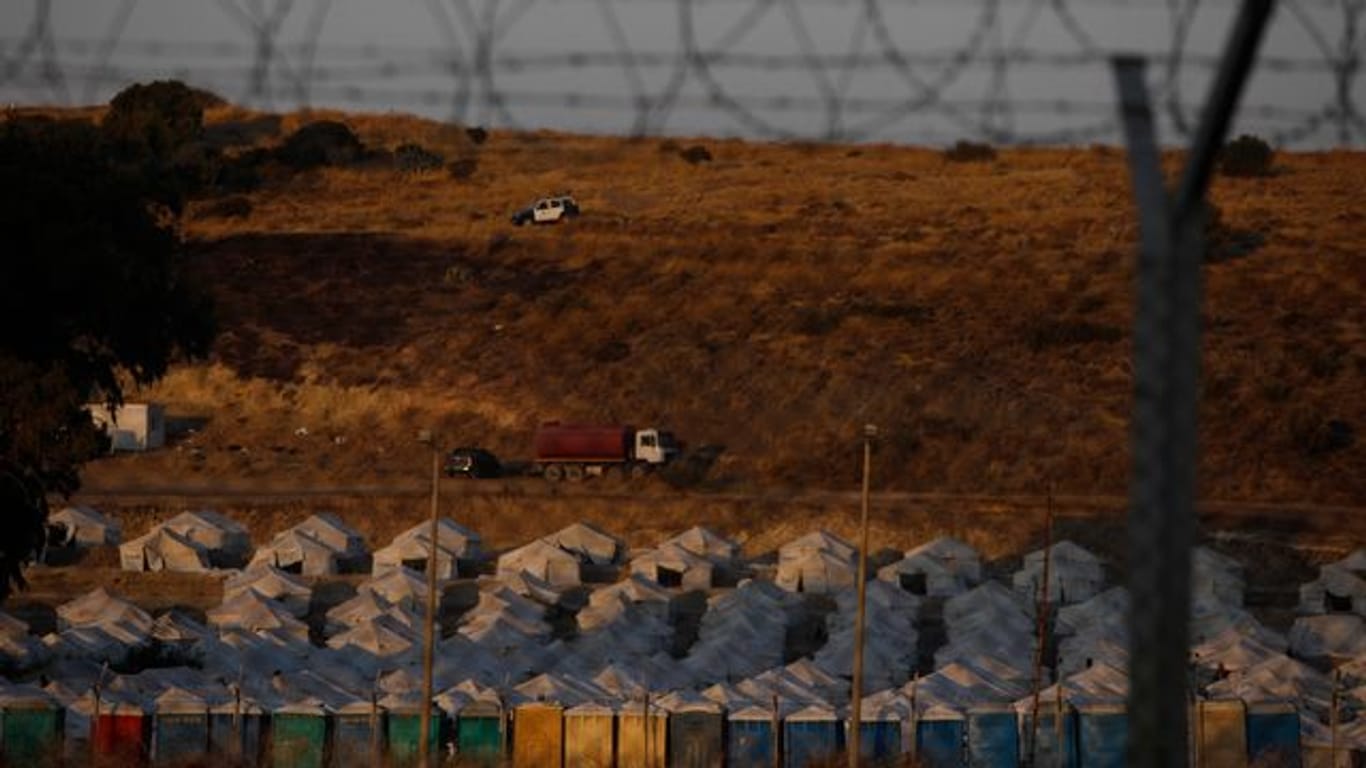 Ein Polizeiauto patrouilliert oberhalb eines provisorischen Zeltlagers für geflüchtete Menschen in der Nähe von Mytilini.