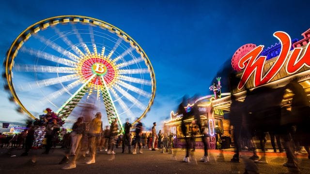 Besucher genießen zur blauen Stunde das 81. Stuttgarter Frühlingsfest auf dem Cannstatter Wasen (Archivbild): Das Fest fällt dieses Jahr wohl erneut aus.