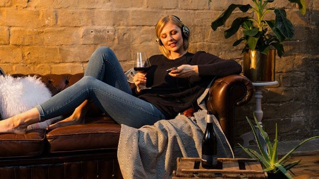 Gemütlich auf der Couch mit einem Glas Wein: Die Weinprobe von zu Hause aus hat einiges für sich.