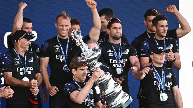 Der neuseeländische Steuermann Pete Burling präsentiert die America's-Cup-Trophäe. Der neuseeländische Steuermann Pete Burling präsentiert die America's-Cup-Trophäe.
