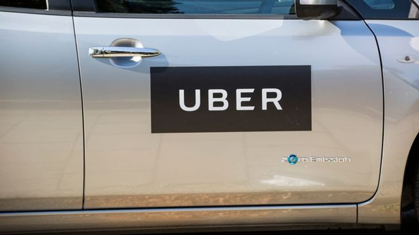 Das Firmenlogo von Uber an einer Autotür in London.