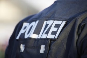 Ein Polizist von hinten (Symbolbild): Die Polizei hat nach den Schüssen im Allerheiligenviertel in Frankfurt eine Razzia durchgeführt.