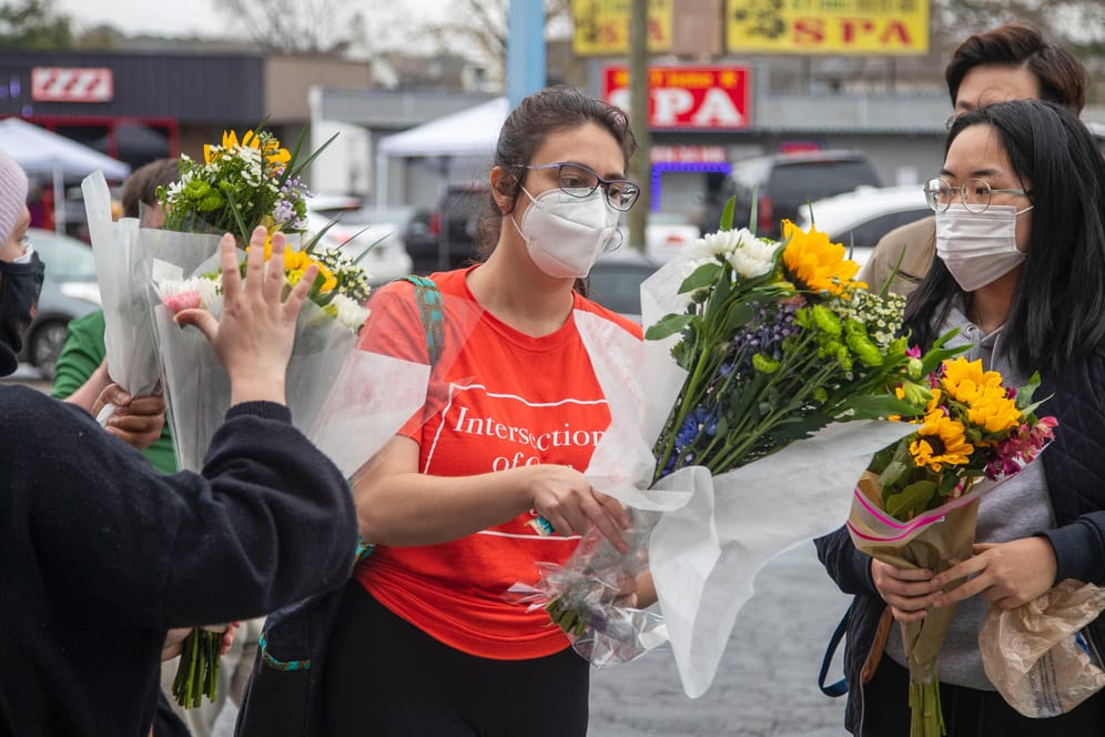 Zwei Frauen legen Blumen an einem der Massage-Salons nieder. Sechs aus Asien stammende Frauen wurden getötet.