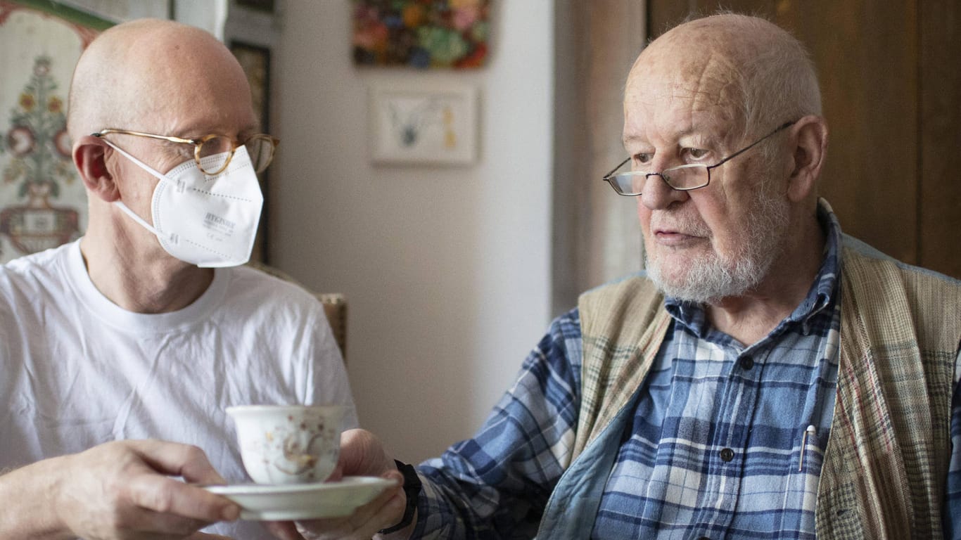 Ein Altenpfleger bei der Arbeit mit einem Patienten im häuslichen Umfeld (Archivbild). Eine Neuinfektion ist bei älteren Menschen nicht ausgeschlossen.