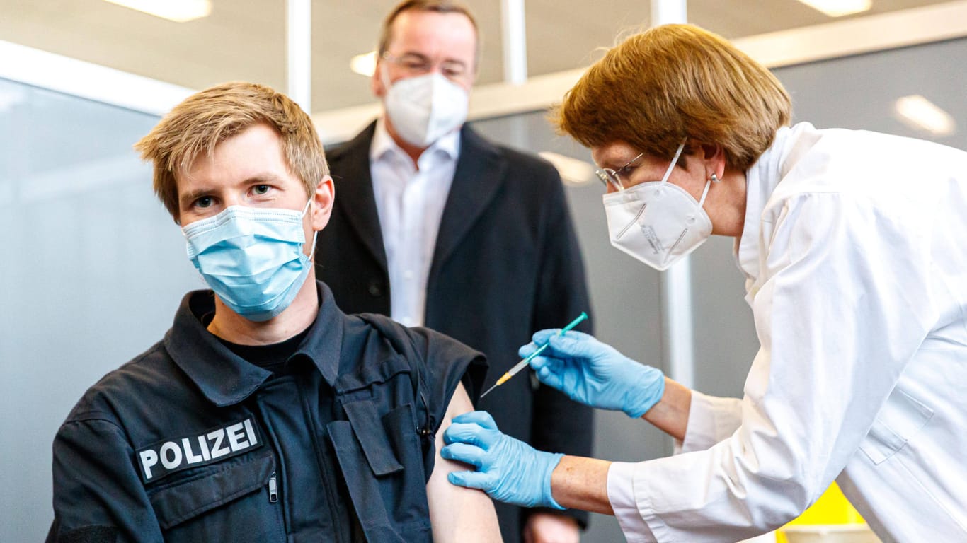 Ein Polizist erhält eine Corona-Impfung (Symbolbild): Polizeibeamte in Berlin können den Impfstoff wählen, den sie erhalten.