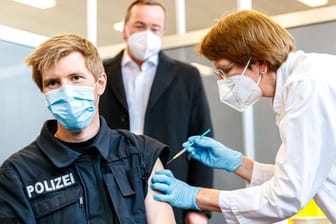 Ein Polizist erhält eine Corona-Impfung (Symbolbild): Polizeibeamte in Berlin können den Impfstoff wählen, den sie erhalten.