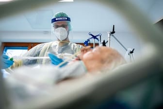 Ein Intensivpfleger arbeitet in Schutzausrüstung auf der Intensivstation des Krankenhauses Bethel in Berlin an einem Corona-Patienten.