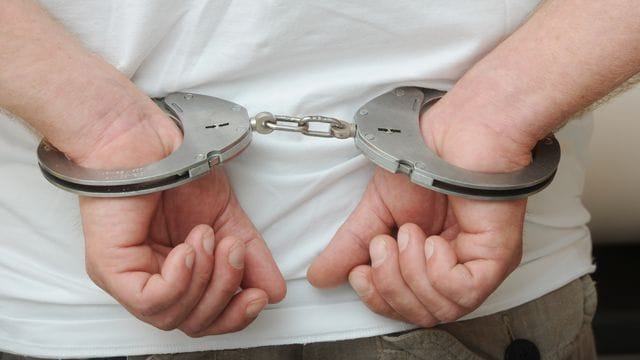 Hände in Handschellen (Symbolbild): Bei der Durchsuchung von zwei Wohnungen wurde ein Mann festgennommen. Hände in Handschellen (Symbolbild): Bei der Durchsuchung von zwei Wohnungen wurde ein Mann festgennommen.