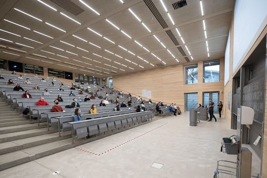 Studierende mit Mund- und Nasenmaske sitzen in der Begrüßungsveranstaltung für Studierende im ersten Semester an der Universität Hohenheim.