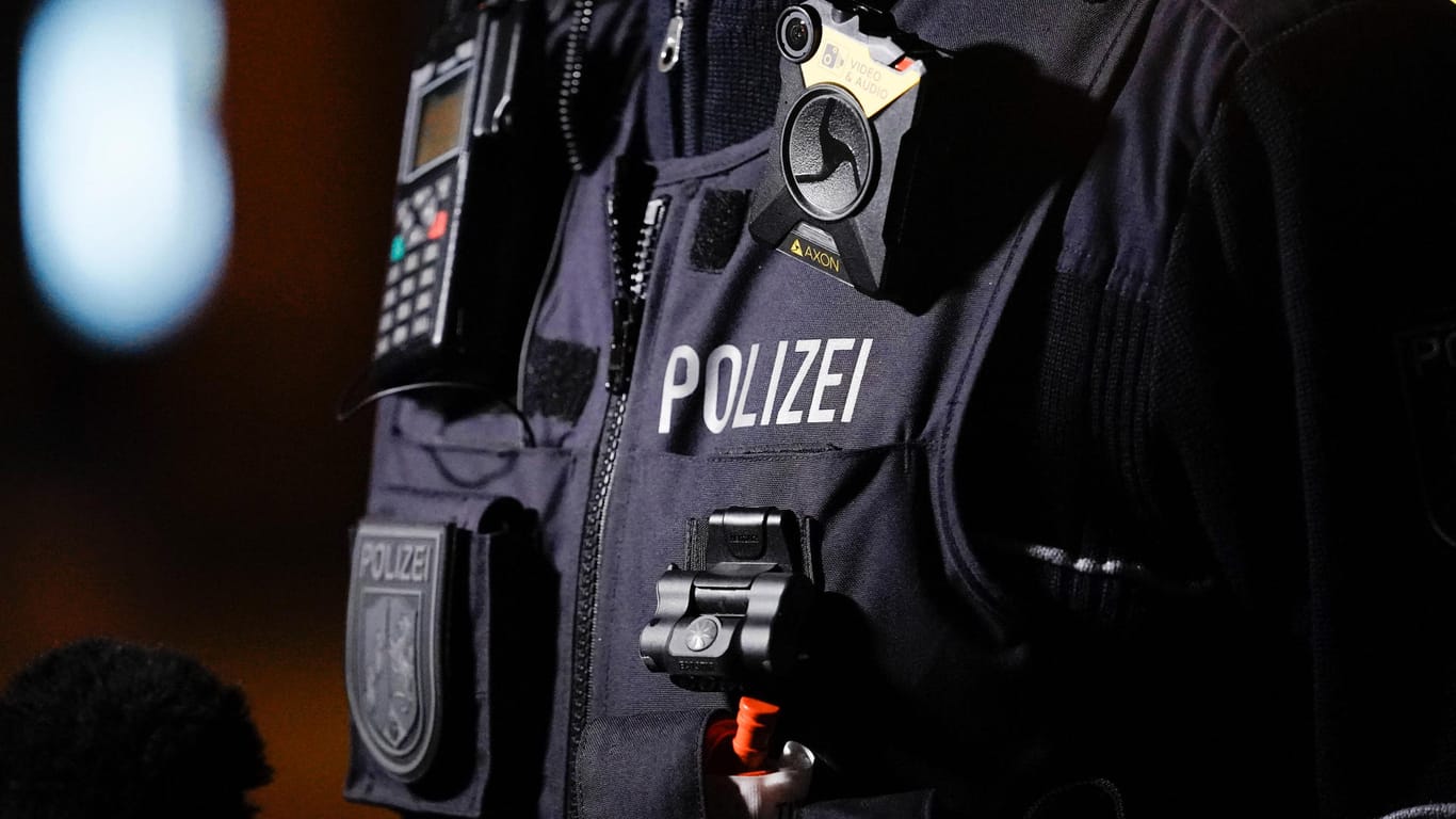 Eine Person trägt eine Polizeiuniform (Symbolbild): In Köln hat eine Razzia wegen Betrugs mit Corona-Soforthilfen stattgefunden.
