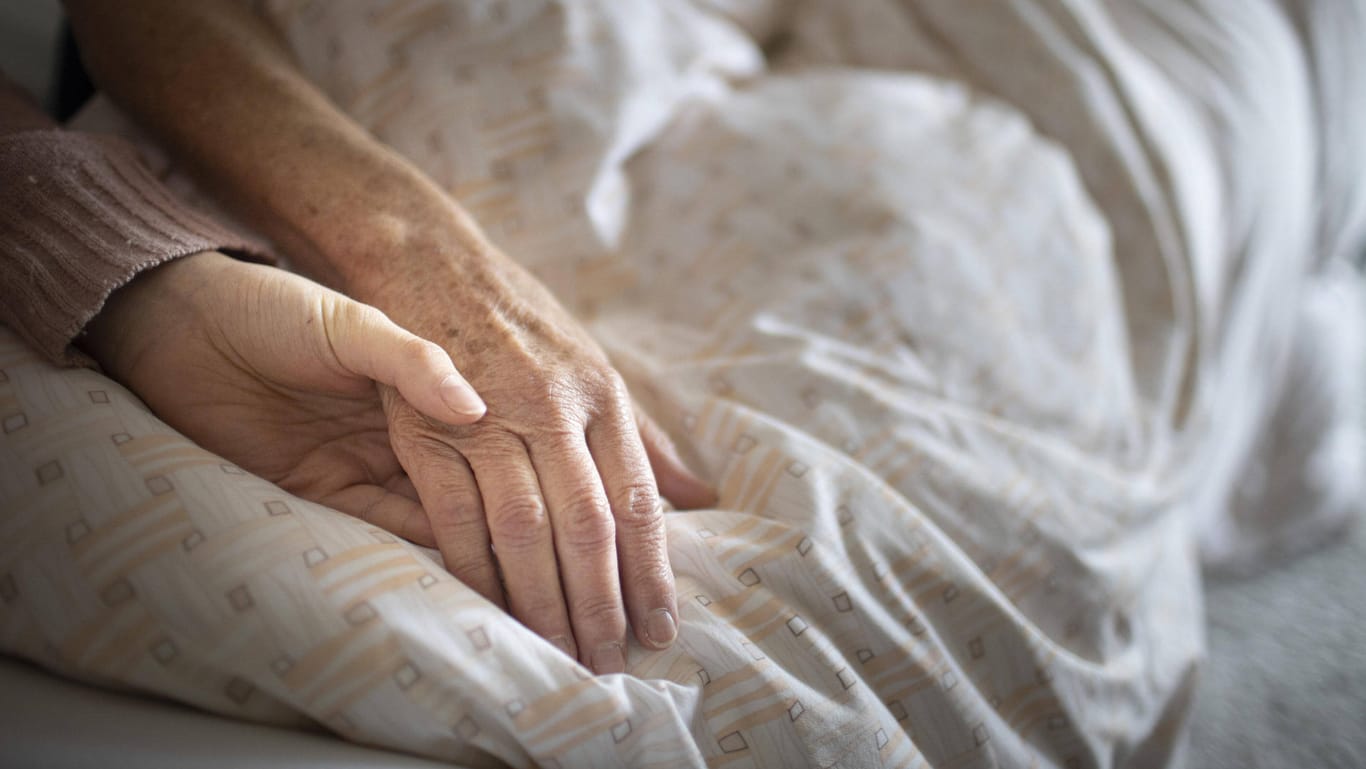 Eine Pflegerin hält die Hand einer älteren Frau (Symbolbild): In Spanien wird die Sterbehilfe legalisiert.