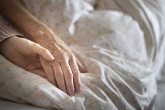 Eine Pflegerin hält die Hand einer älteren Frau (Symbolbild): In Spanien wird die Sterbehilfe legalisiert.