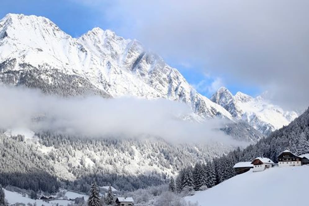 Wolken hängen über einem verschneiten Tal in Antholz, Südtirol.