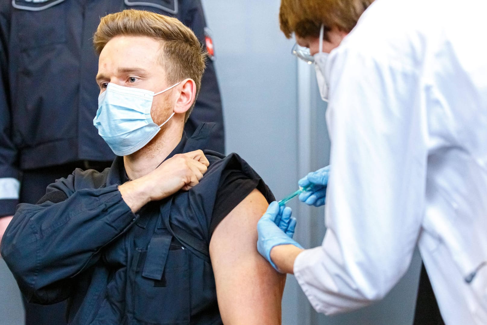 Ein Polizist wird geimpft: Astrazeneca darf wieder gespritzt werden.