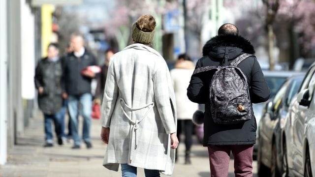 Menschen spazieren in Essen und genießen das sonnige Wetter.
