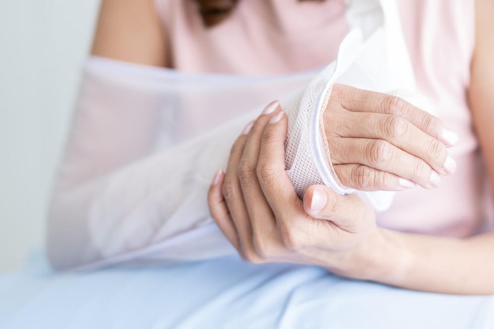 Frau mit gebrochenem Arm: Frakturen nach leichten Stürzen oder aus geringem Anlass können ein Hinweis auf Osteoporose sein.
