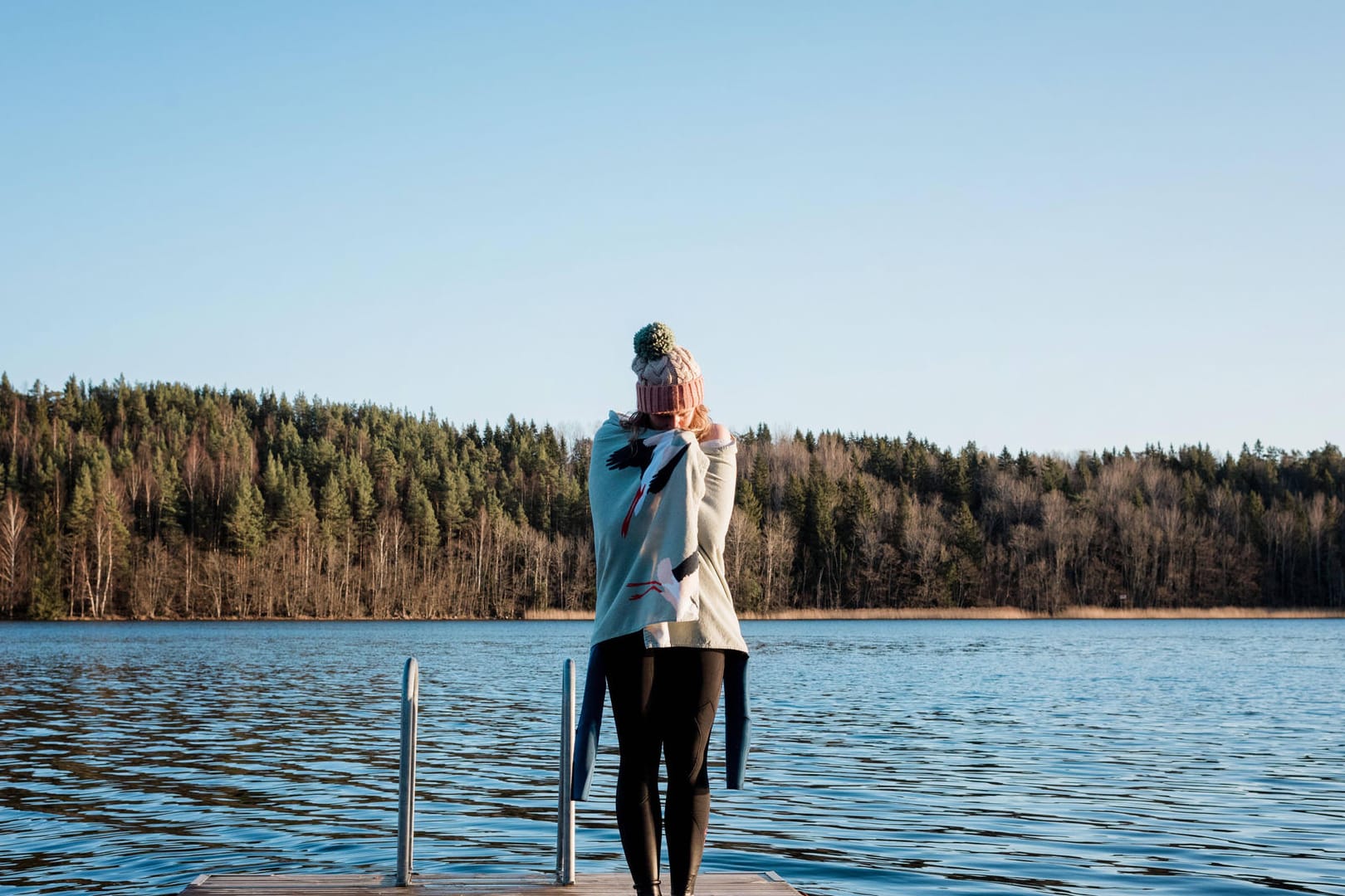 Eine Frau ist nach dem Baden im kalten Wasser in eine Decke gehüllt (Symbolbild): Die Karlsruherin Svetlana Dineva hat das Kaltbaden für sich entdeckt.