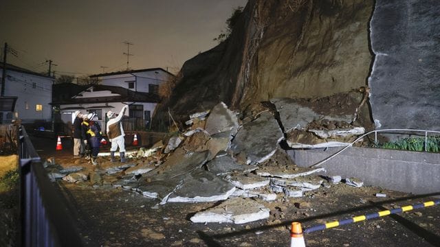 Menschen stehen vor eingestürzten Teilen einer Klippe. Menschen stehen vor eingestürzten Teilen einer Klippe.