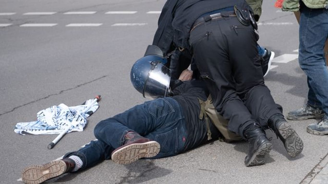 Ein Teilnehmer einer Demonstration von Rechtsextremisten und sogenannten Reichsbürgern wird von der Polizei am Brandenburger Tor in Berlin festgenommen.
