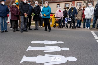 Trauernde stehen während der Mahnwache für die Opfer eines Unfalls auf einem Überweg: Am 16. März 2021 hatte ein Autofahrer in Leipzig an einer Fußgängerampel eine Gruppe von Menschen erfasst, wobei drei Menschen starben.