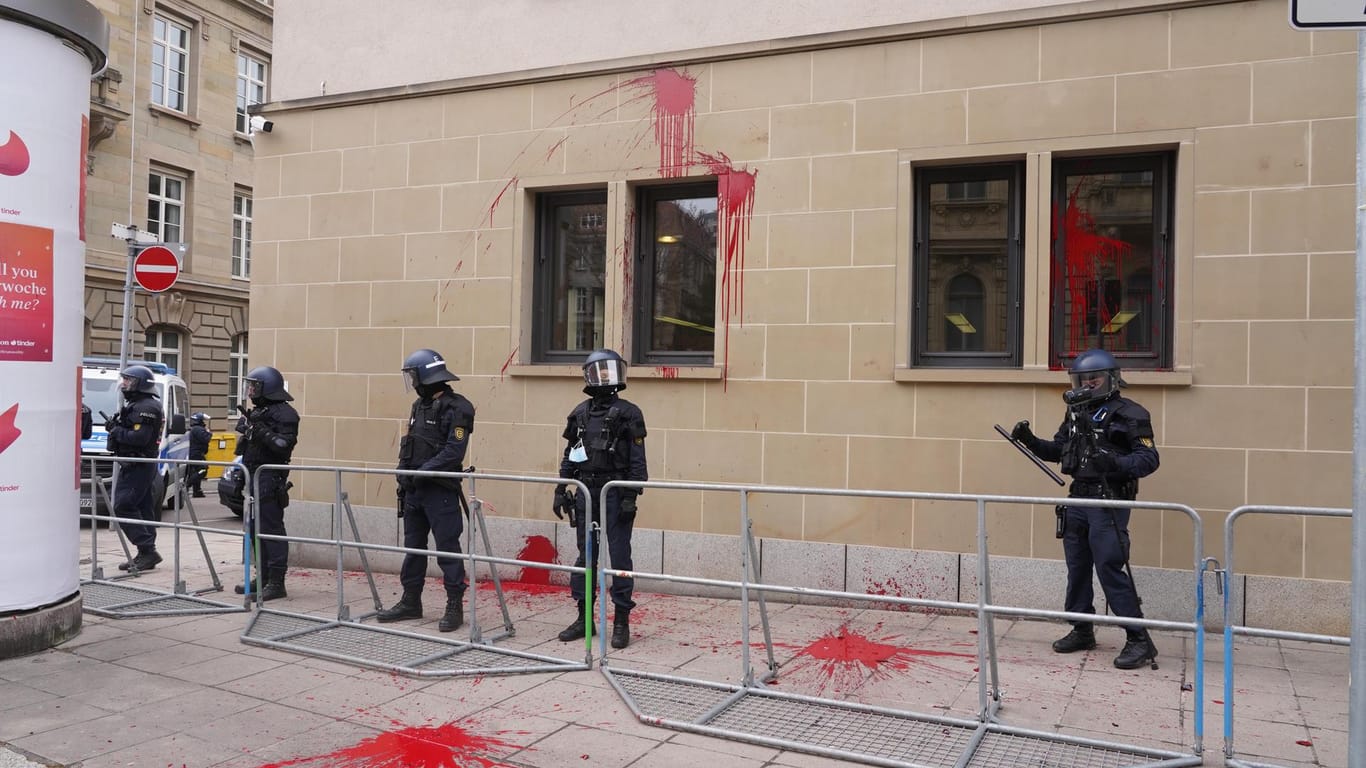 Polizisten stehen vor dem Gebäude des Landgerichts, das von Teilnehmern einer Demonstration mit roter Farbe beworfen worden ist: Die Teilnehmer waren zuvor durch die Innenstadt von Stuttgart gezogen.