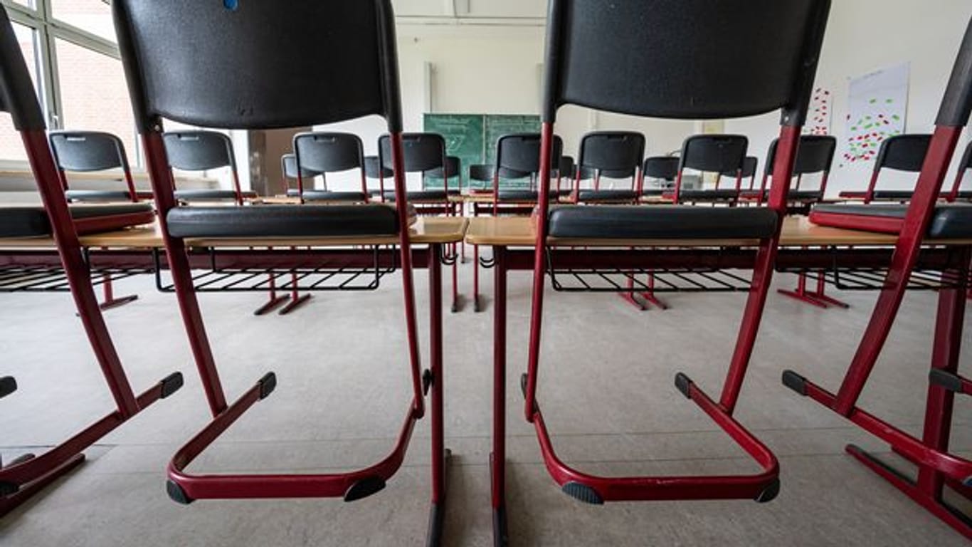Stühle stehen in einem leeren Klassenzimmer auf den Tischen (Symbolbild): In Wuppertal dürfen weiterführende Schulen wieder in den Distanzunterricht wechseln.