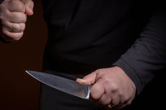 Eine Person droht mit einem Messer (Symbolbild): Am Wochenende wurde eine Kölnerin von einem Mann mit einem Messer verletzt.