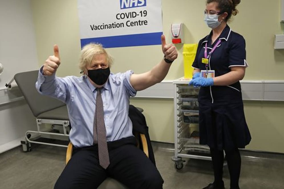 Boris Johnson (l), Premierminister von Großbritannien, hebt die Daumen in die Höhe, nachdem er die erste Impfdosis mit dem Corona-Impfstoff von AstraZeneca erhalten hat.