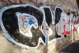 Graffiti an einer Wand (Symbolbild): In Hagen sind zwei Sprayer Polizisten aggressiv angegangen.