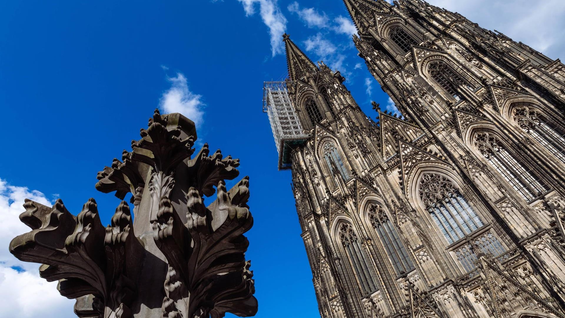 Die Kreuzblume vor dem Kölner Dom (Archivbild): Der Kardial-Höffner-Platz unterhalb der Domplatte soll umbenannt werden, fordern erste Stimmen. Die Kreuzblume vor dem Kölner Dom (Archivbild): Der Kardial-Höffner-Platz unterhalb der Domplatte soll umbenannt werden, fordern erste Stimmen.