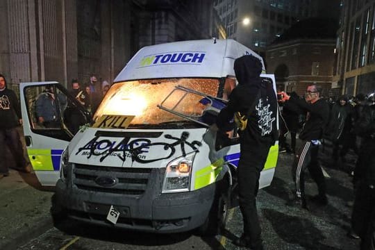 Demonstranten setzen einen Polizeiwagen vor der Bridewell Polizeiwache Brand.