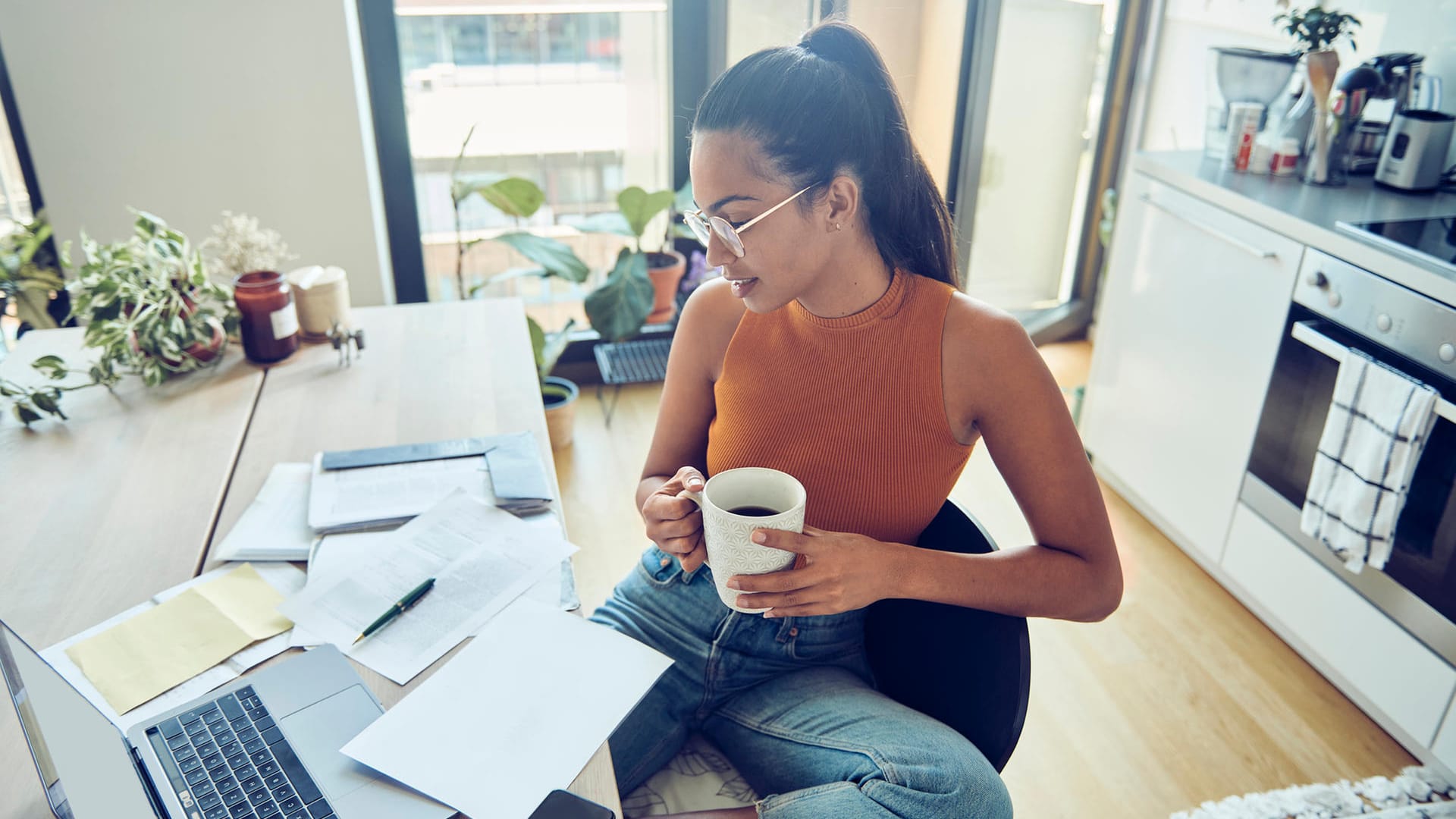 Eine Frau erledigt Papierkram (Symbolbild): Auf Kapitalerträge wird Quellensteuer fällig – auch im Ausland.