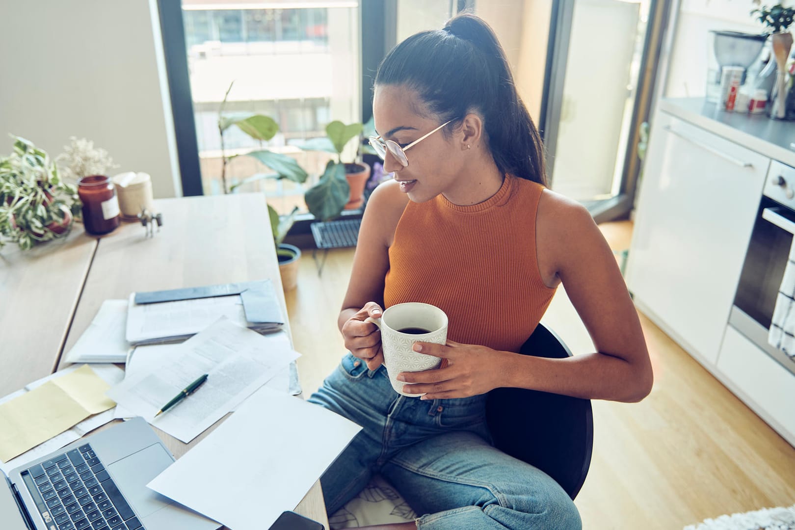 Eine Frau erledigt Papierkram (Symbolbild): Auf Kapitalerträge wird Quellensteuer fällig – auch im Ausland.