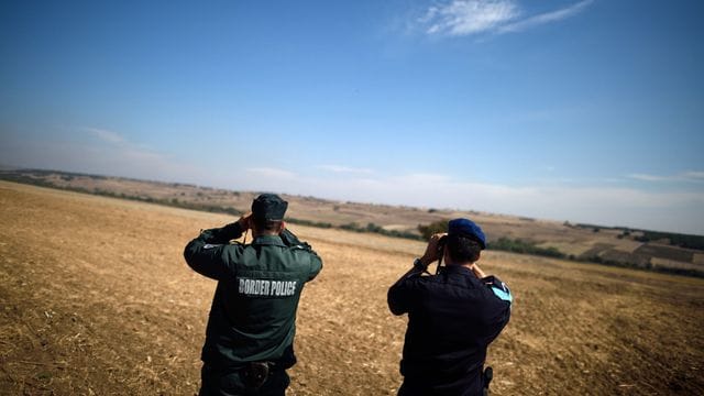 Zwei Beamte der europäischen Grenzschutzagentur Frontex aus Bulgarien (l) und den Niederlanden beobachten mit Ferngläsern die bulgarisch-türkische Grenze. Zwei Beamte der europäischen Grenzschutzagentur Frontex aus Bulgarien (l) und den Niederlanden beobachten mit Ferngläsern die bulgarisch-türkische Grenze.