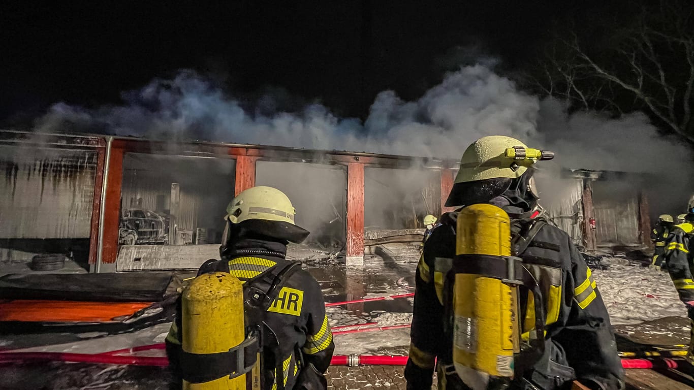 Feuerwehrmänner vor den gelöschten Garagen: Es entstand ein Schaden von 200.000 Euro.