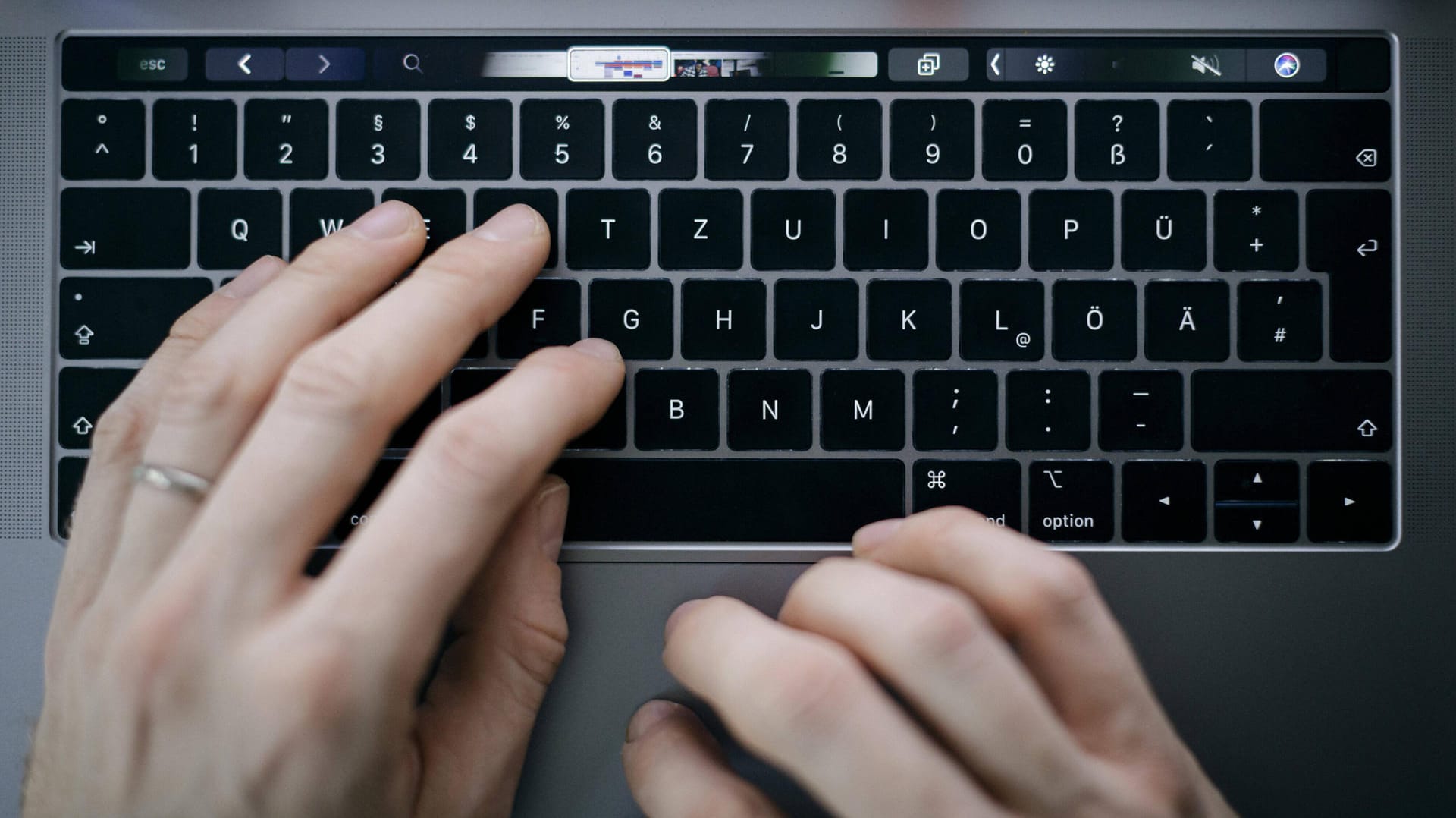 Ein Mann tippt auf einem Macbook (Symbolbild): Wegen anhaltendem Ärger mit der sogenannten Butterfly-Tastatur steht Apple in den USA eine Sammelklage bevor.