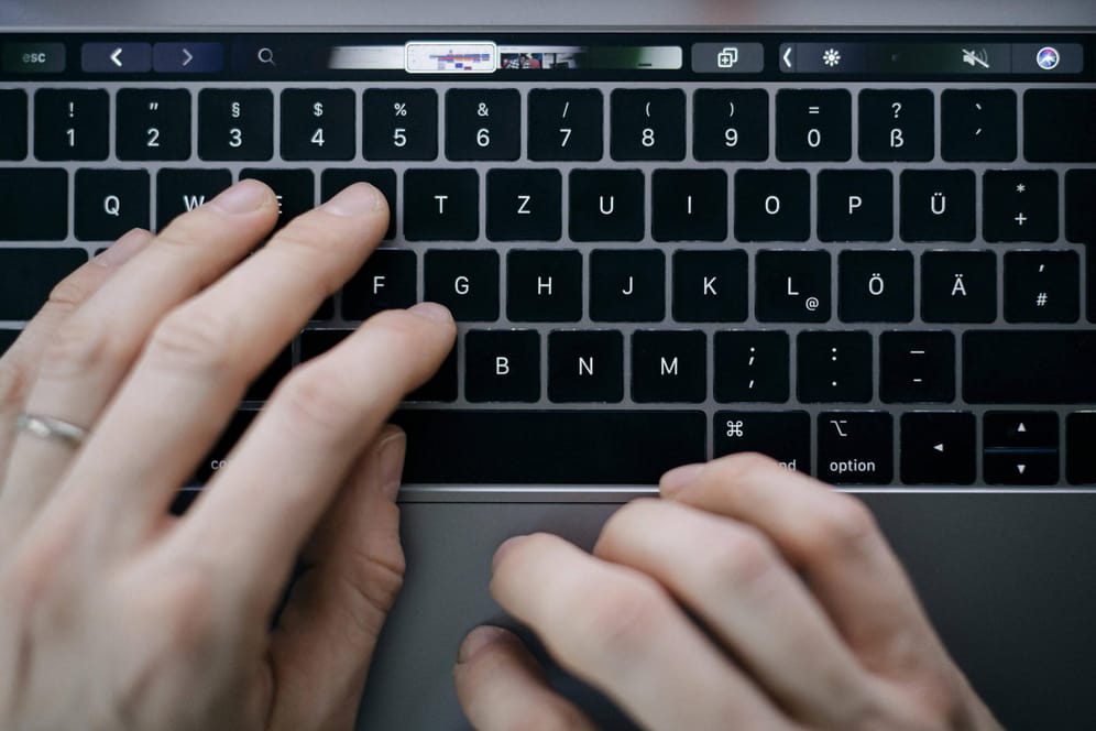 Ein Mann tippt auf einem Macbook (Symbolbild): Wegen anhaltendem Ärger mit der sogenannten Butterfly-Tastatur steht Apple in den USA eine Sammelklage bevor.