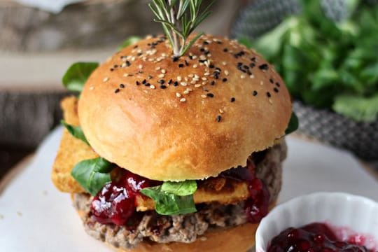 Zwischen die selbst gebackenen Brötchen-Hälften werden Hackfleisch-Patties, panierte Camembert-Streifen, Preiselbeeren und Feldsalat geschichtet.