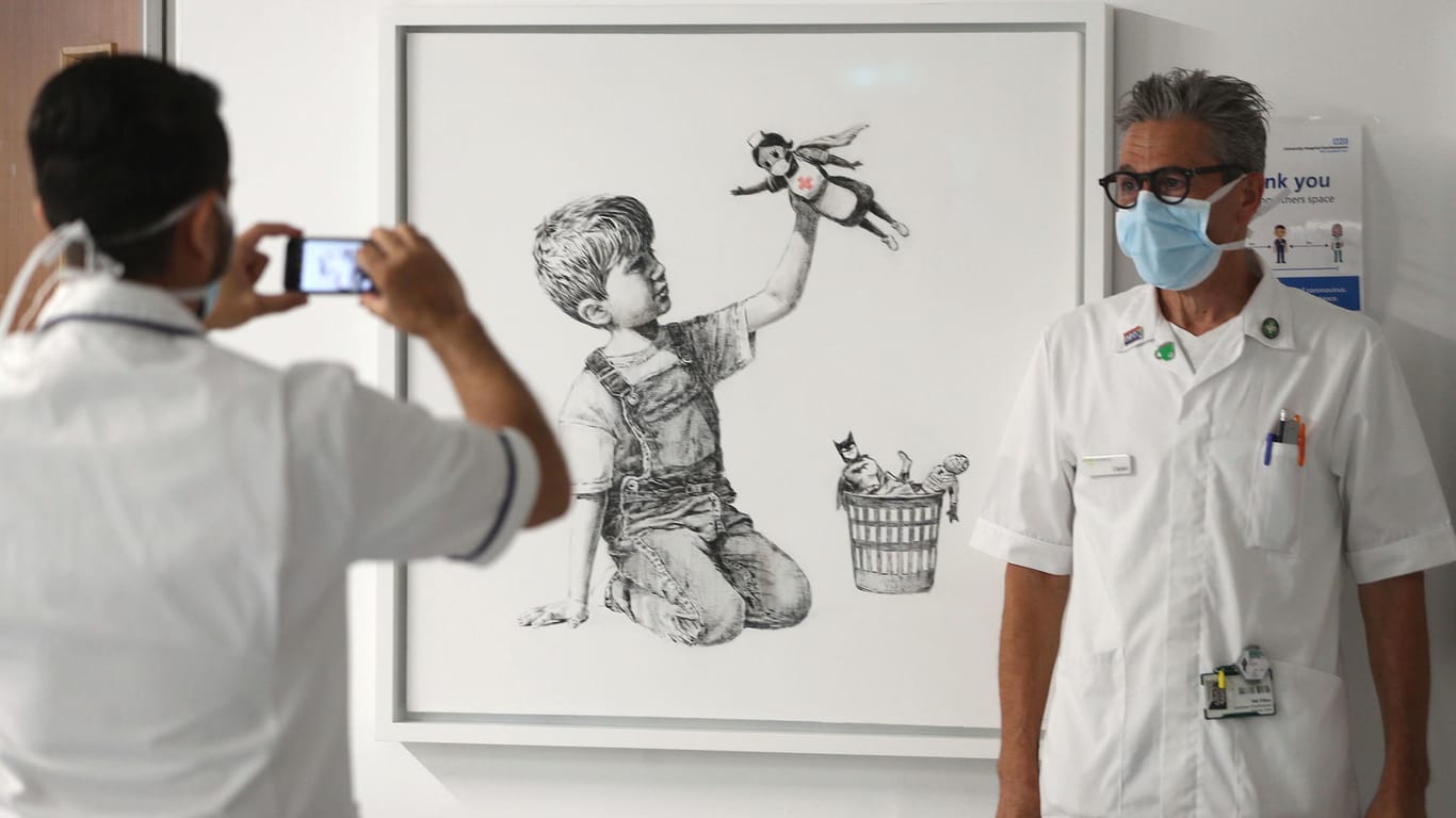 Ein Krankenhausmitarbeiter lässt sich vor dem Werk "Game Changer" von Banksy fotografieren: Der Schätzwert hatte bei 2,5 bis 3,5 Millionen Pfund gelegen.