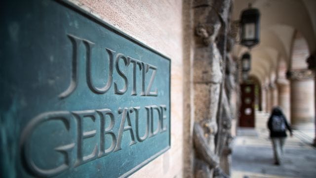 Ein Schild mit der Aufschrift "Justizgebäude" hängt am Eingang vom Landgericht Nürnberg-Fürth (Archivbild): Nach einem tödlichen Messerangriff ist ein Mann zu einer Haftstrafe verurteilt worden.