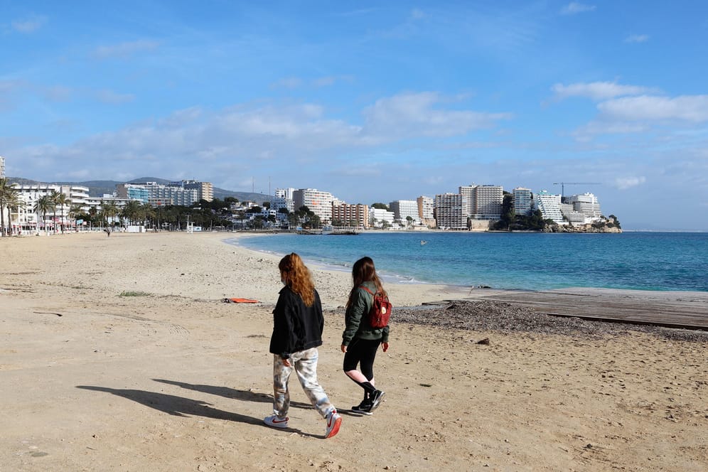 Touristen am Strand auf Mallorca: Die Regierung prüft, ob Urlaubsreisen in bestimmte Gebiete verboten werden können.