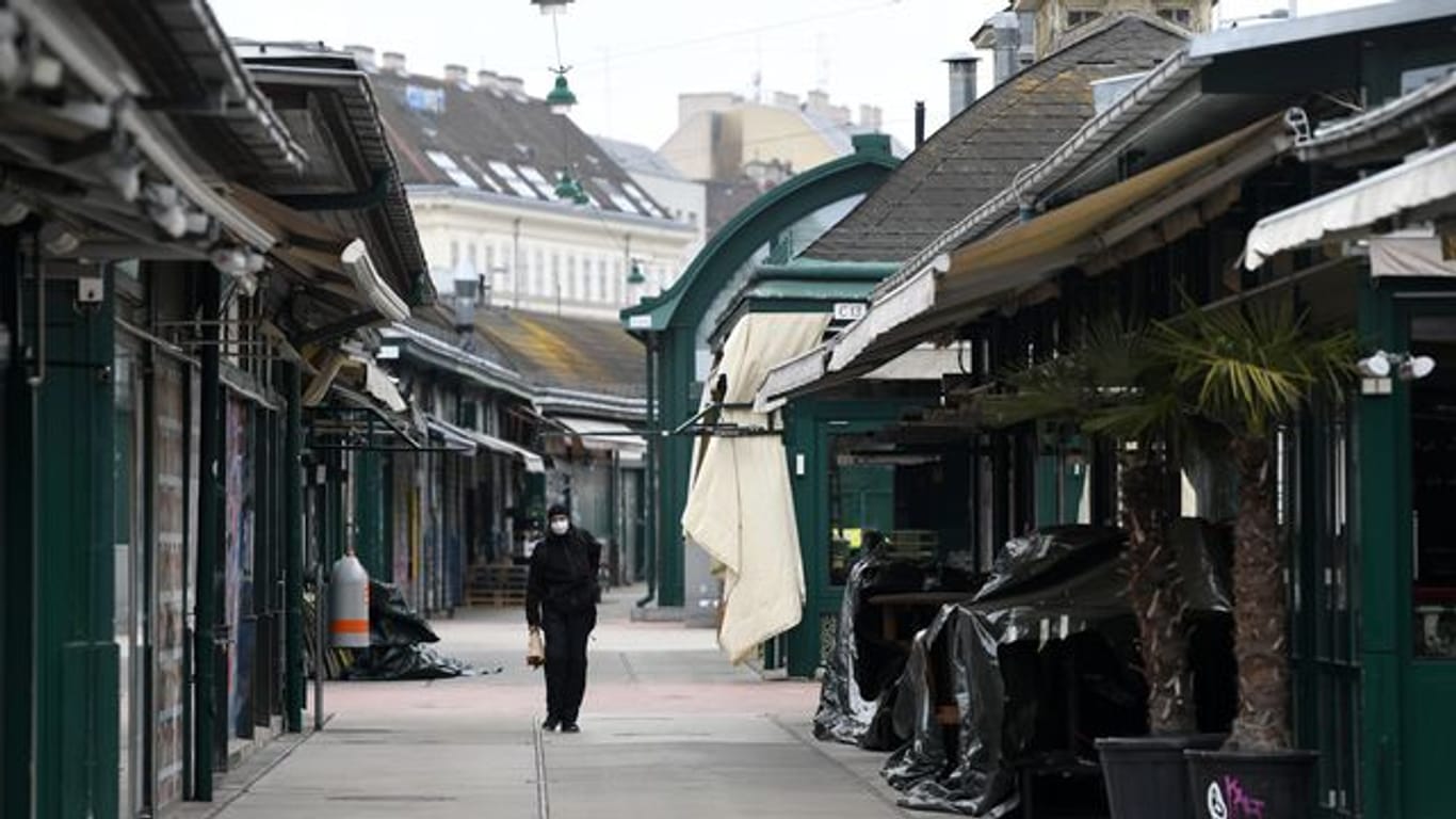 Ein Mann läuft am geschlossenen Wiener Naschmarkt entlang.