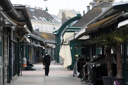Ein Mann läuft am geschlossenen Wiener Naschmarkt entlang.